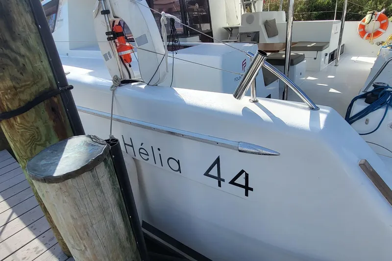 Knot On Call Yacht Photos Pics 2018 Fountaine Pajot Helia 44 catamaran docked, featuring sleek white design and safety equipment.