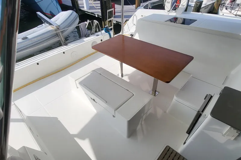Knot On Call Yacht Photos Pics 2018 Fountaine Pajot Helia 44 yacht cockpit with wooden table and seating.