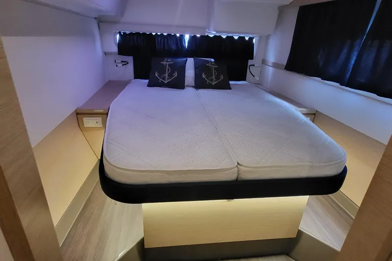 Knot On Call Yacht Photos Pics 2018 Fountaine Pajot Helia 44 cabin interior with bed and anchor-themed pillows.