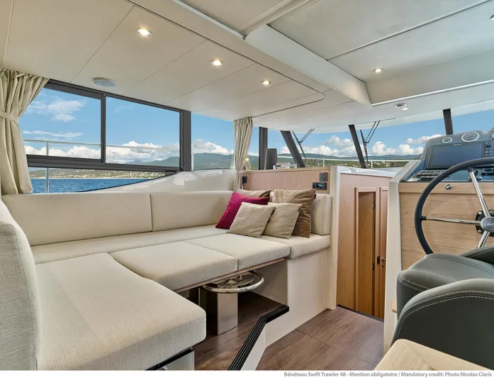 Demo Yacht Photos Pics Luxurious interior of 2025 Beneteau Swift Trawler 48 with panoramic windows and plush seating.