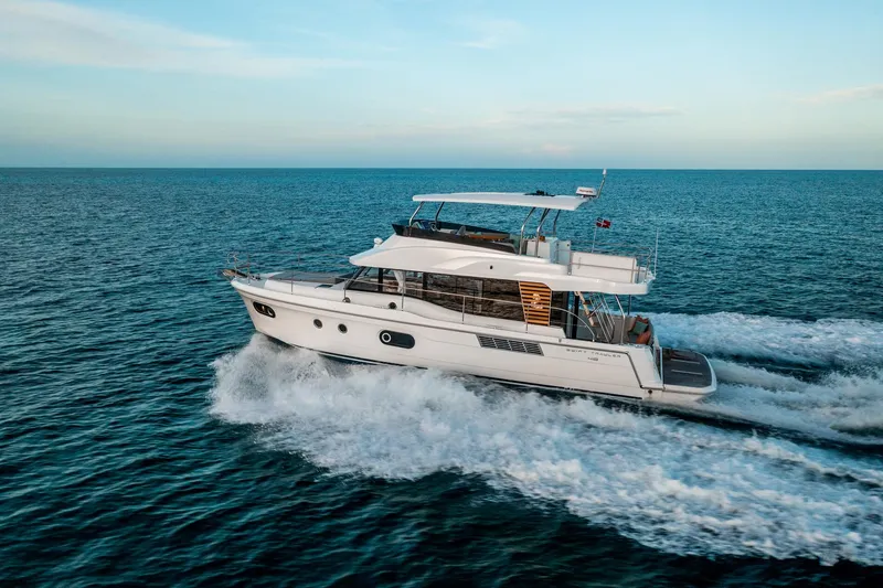Demo Yacht Photos Pics 2025 Beneteau Swift Trawler 48 cruising on open sea under clear sky.