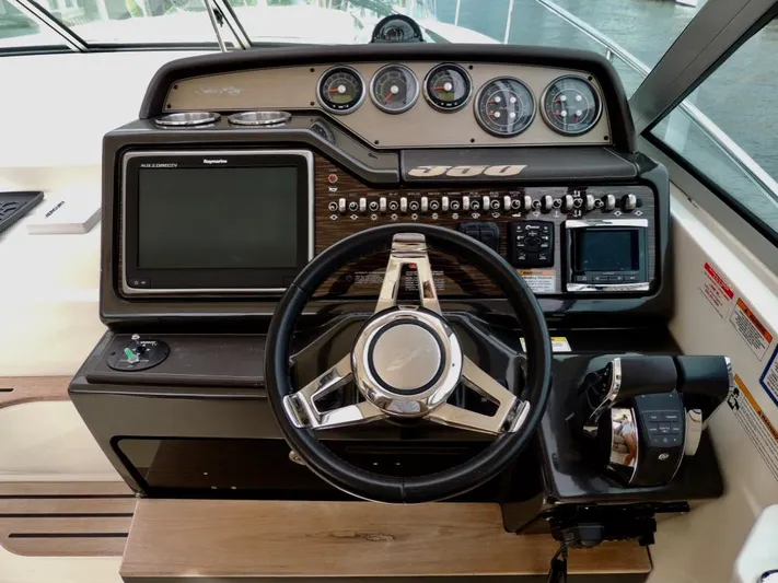  Yacht Photos Pics 2016 Sea Ray 350 Sundancer helm with steering wheel, gauges, and navigation controls.