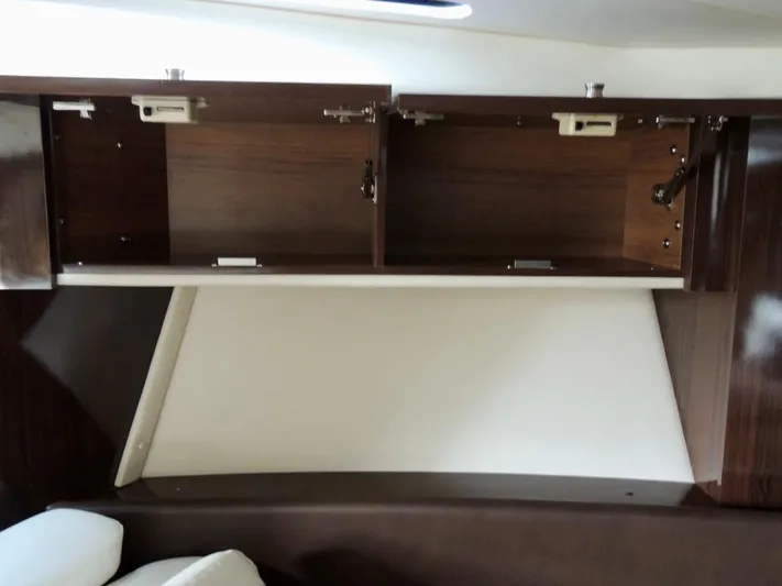  Yacht Photos Pics Open wooden cabinets inside a 2016 Sea Ray 350 Sundancer boat interior.