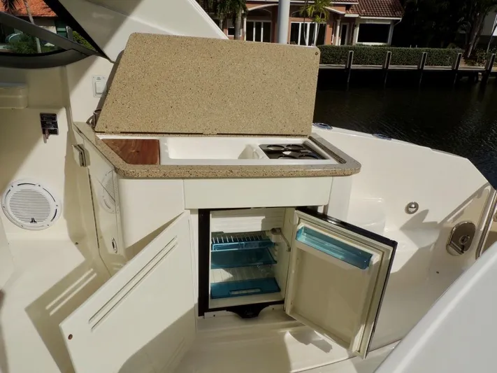  Yacht Photos Pics 2016 Sea Ray 350 Sundancer boat kitchenette with open fridge and storage compartments.