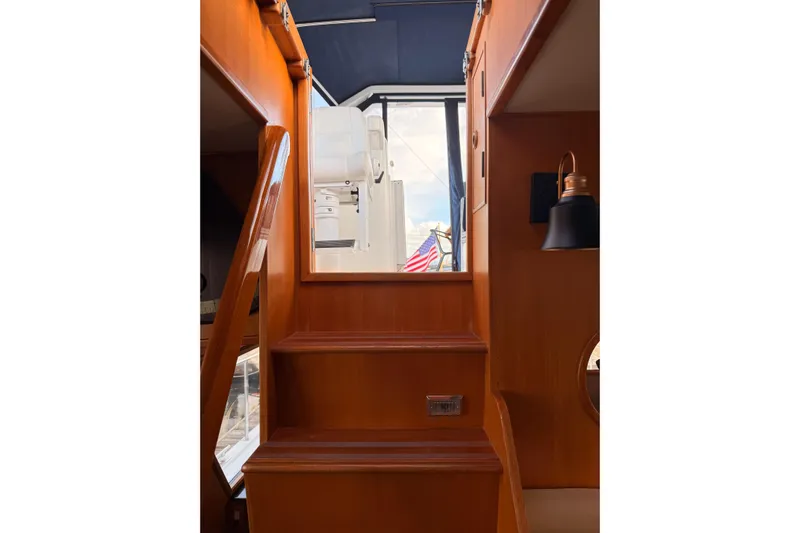 Island Girl Yacht Photos Pics Interior stairs of 1997 Ocean Alexander 486 Pilothouse with wooden finish and nautical decor.