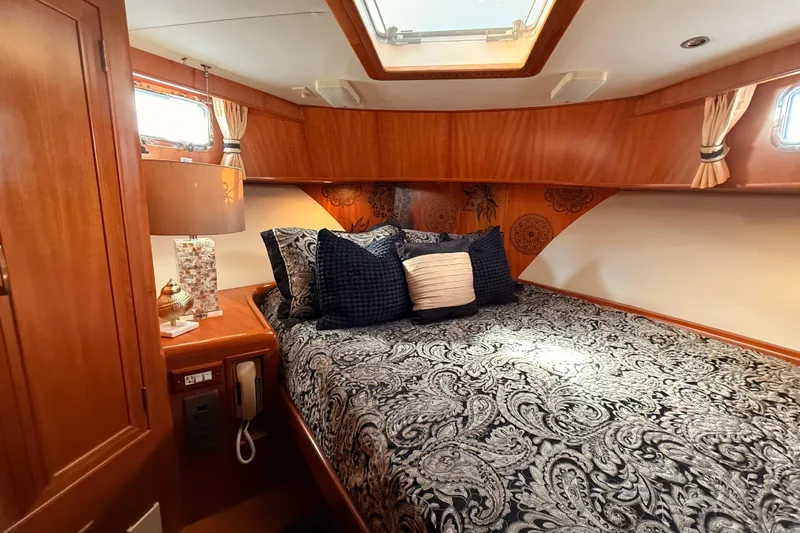 Island Girl Yacht Photos Pics Luxurious 1997 Ocean Alexander 486 Pilothouse bedroom with elegant bedding and wood accents.