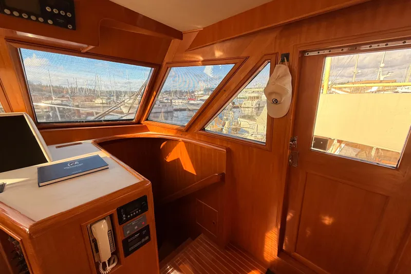 Island Girl Yacht Photos Pics Interior view of 1997 Ocean Alexander 486 Pilothouse with wooden finish and marina view.