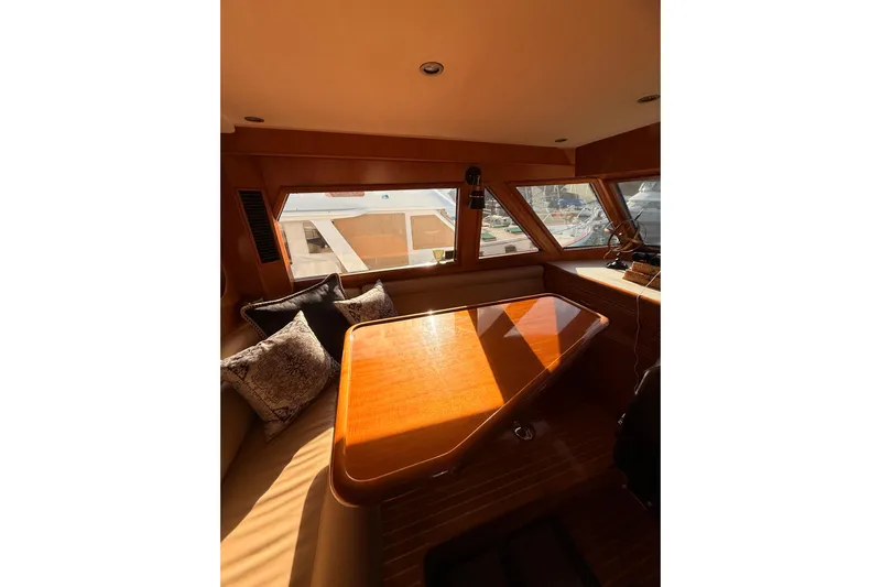 Island Girl Yacht Photos Pics Luxurious interior of 1997 Ocean Alexander 486 Pilothouse yacht with wooden table and cushions.