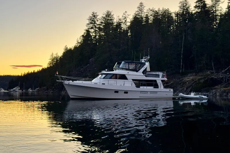 Island Girl Yacht Photos Pics 1997 Ocean Alexander 486 Pilothouse yacht anchored at sunset near forested shoreline.