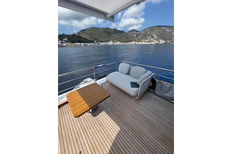  Yacht Photos Pics Luxurious 2024 Azimut 60 yacht deck with sofa, table, and scenic ocean view.