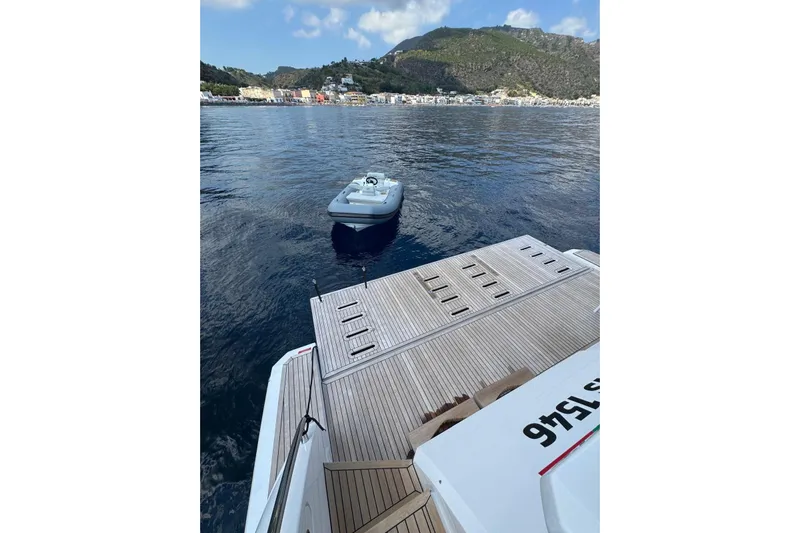  Yacht Photos Pics 2024 Azimut 60 yacht with tender, docked in scenic coastal waters.