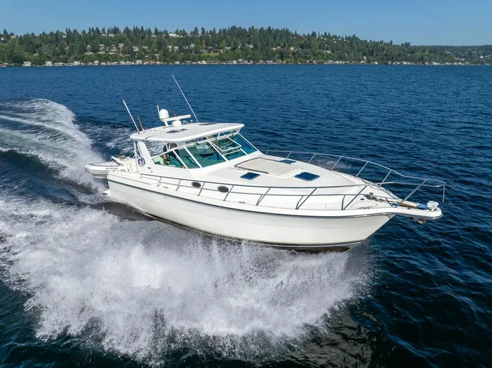  Yacht Photos Pics 2001 Tiara Sport 4000 EXPRESS cruising on a scenic lake with forested shoreline.