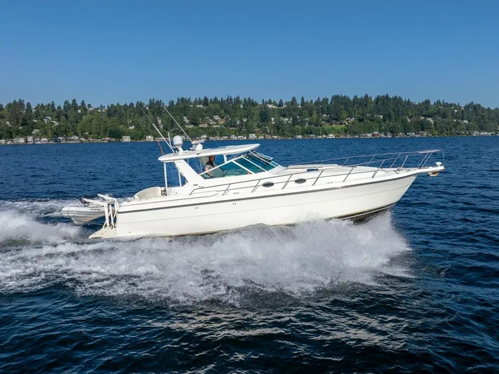  Yacht Photos Pics 2001 Tiara Sport 4000 EXPRESS cruising on a lake with forested shoreline.