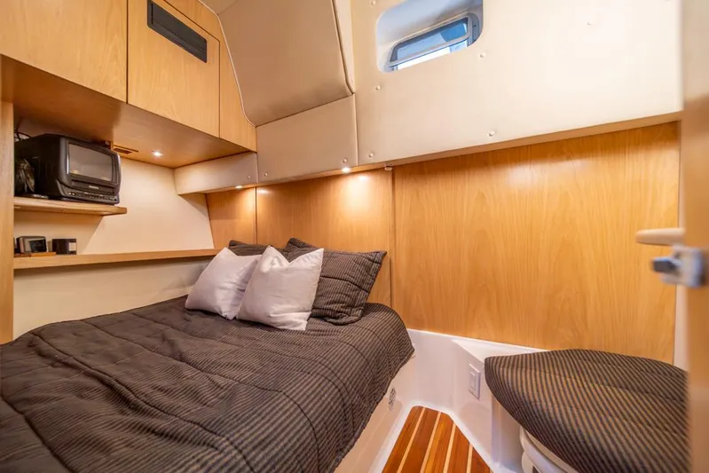  Yacht Photos Pics Cozy cabin interior of 2001 Tiara Sport 4000 EXPRESS with bed, TV, and wooden accents.