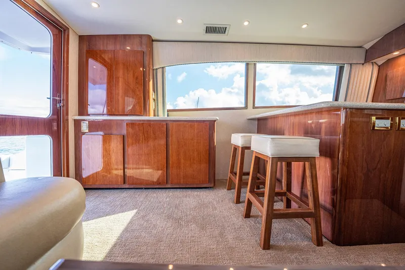 Manana Yacht Photos Pics Luxurious interior of 2007 Egg Harbor 43 SportYacht with wooden cabinetry and bar stools.