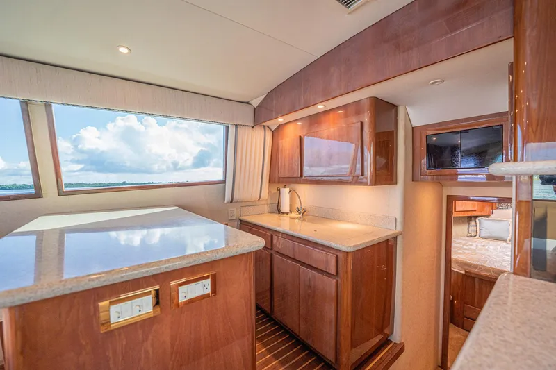 Manana Yacht Photos Pics Luxurious interior of 2007 Egg Harbor 43 SportYacht with wood cabinetry and large windows.