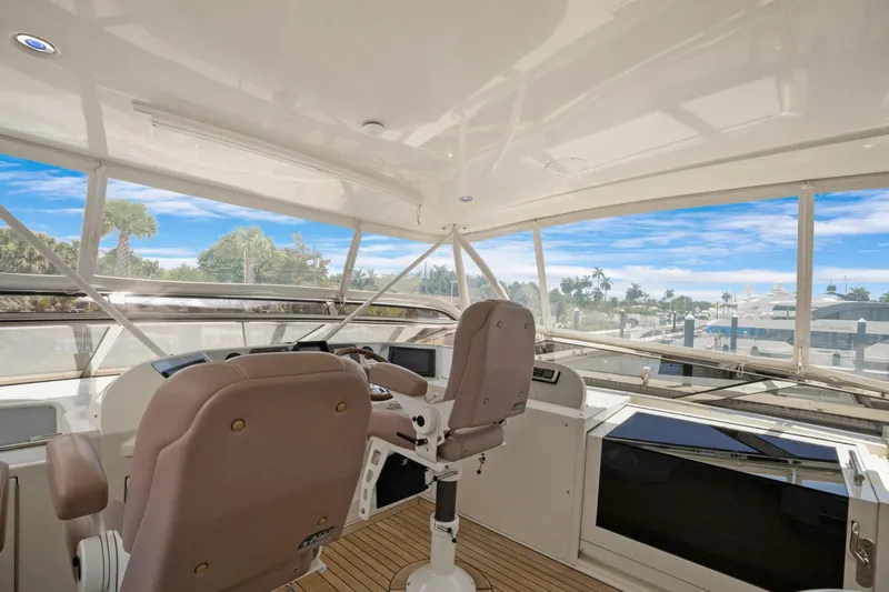 Her Endeavour Yacht Photos Pics Interior view of 2008 Marquis 690 yacht cockpit with panoramic windows and captain's chairs.