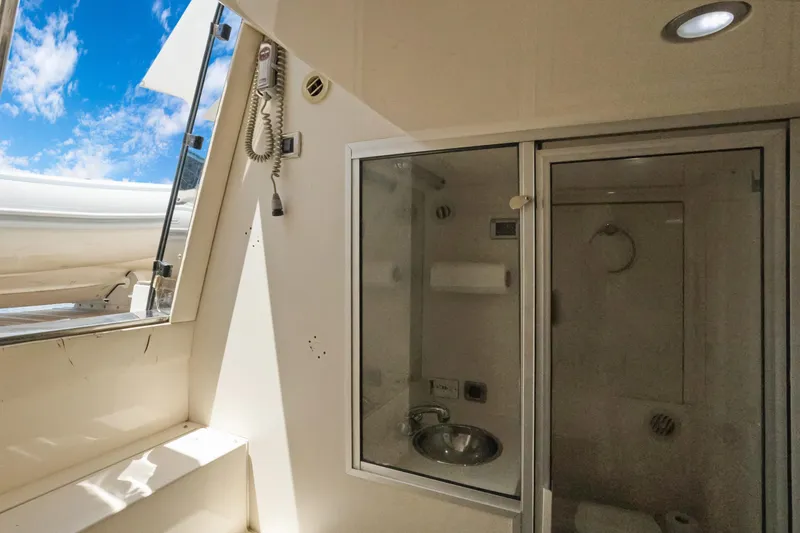 Her Endeavour Yacht Photos Pics 2008 Marquis 690 yacht bathroom with shower, sink, and open window under blue sky.