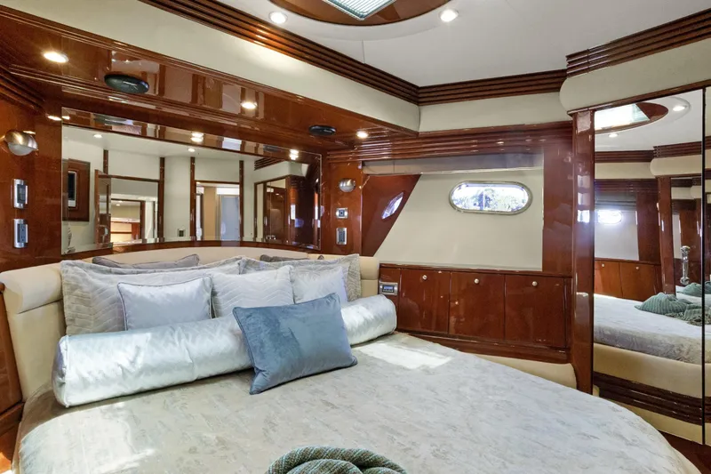 Her Endeavour Yacht Photos Pics Luxurious 2008 Marquis 690 yacht bedroom with elegant wood finishes and plush bedding.