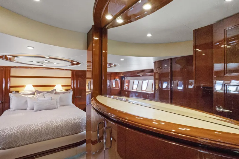 Her Endeavour Yacht Photos Pics Luxurious interior of 2008 Marquis 690 yacht with elegant wood finishes and plush bedding.