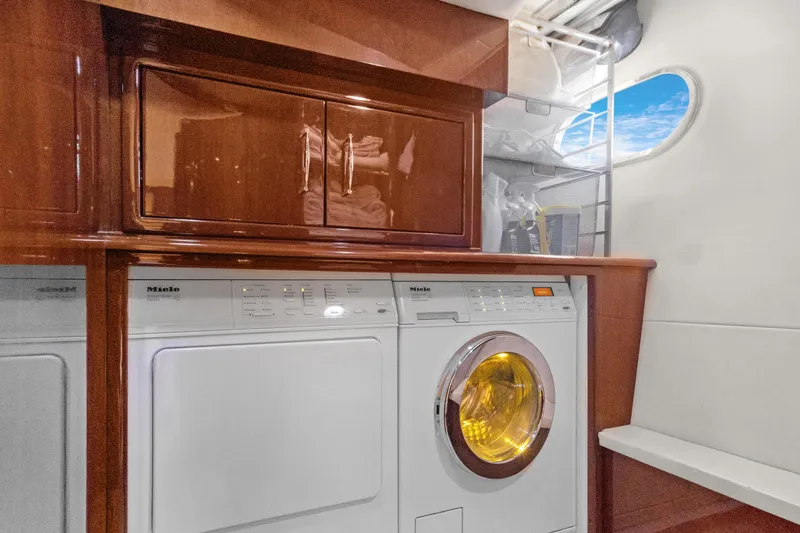 Her Endeavour Yacht Photos Pics Laundry area in 2008 Marquis 690 yacht with Miele appliances and wooden cabinetry.