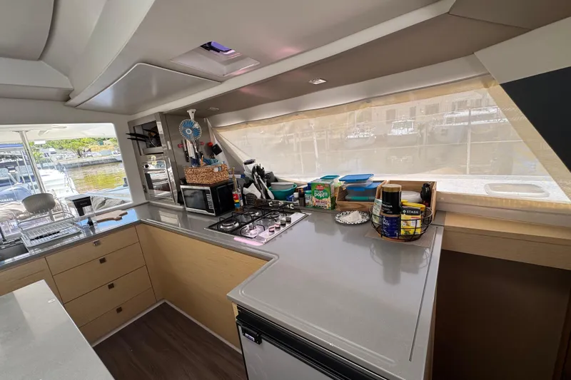 Ten:10 Yacht Photos Pics Modern kitchen interior of 2017 Fountaine Pajot SABA 50 catamaran with appliances and storage.