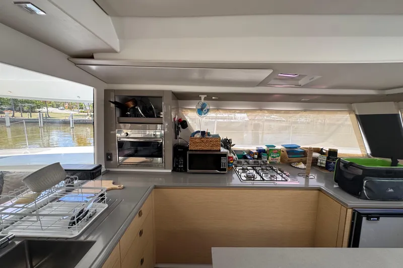 Ten:10 Yacht Photos Pics Modern kitchen interior of 2017 Fountaine Pajot SABA 50 catamaran with appliances and scenic view.