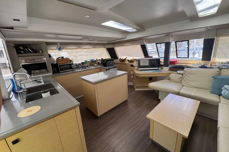 Ten:10 Yacht Photos Pics Luxurious interior of 2017 Fountaine Pajot SABA 50 catamaran with modern kitchen and seating area.