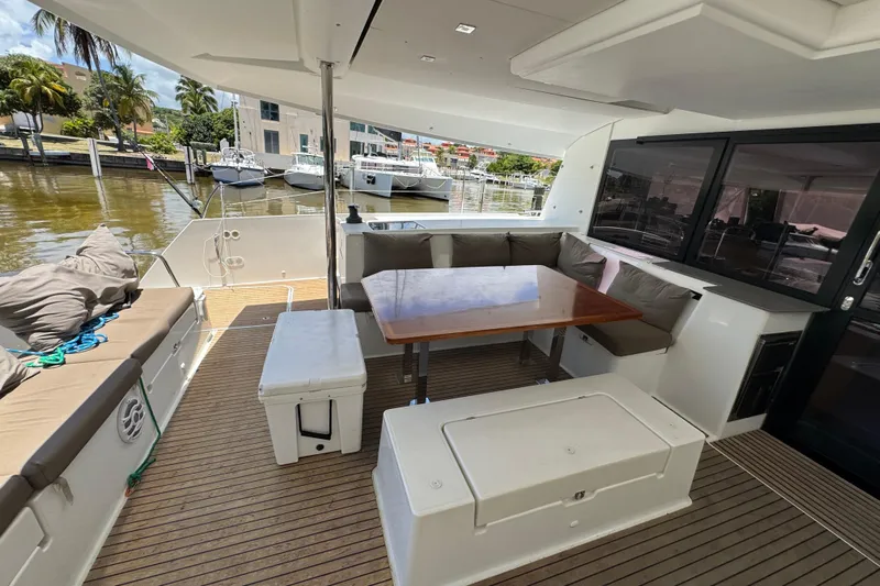 Ten:10 Yacht Photos Pics 2017 Fountaine Pajot SABA 50 yacht deck with seating and table, docked at marina.