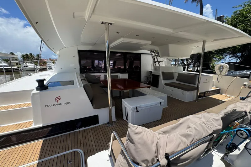 Ten:10 Yacht Photos Pics 2017 Fountaine Pajot SABA 50 yacht deck with seating and table, docked in marina.