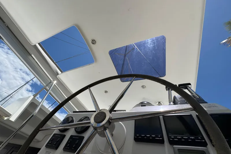 Ten:10 Yacht Photos Pics Steering wheel and controls of 2017 Fountaine Pajot SABA 50 catamaran under clear blue sky.