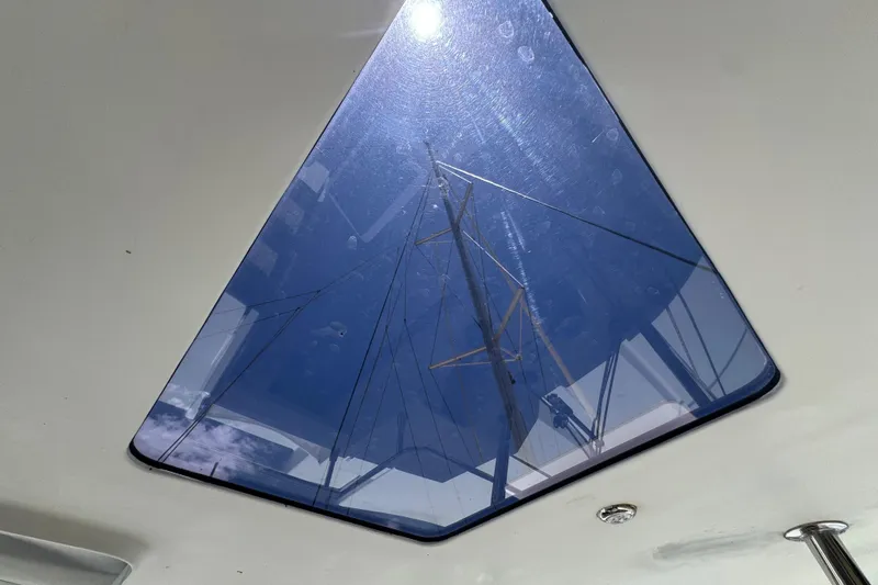 Ten:10 Yacht Photos Pics View through skylight of 2017 Fountaine Pajot SABA 50 catamaran, showing mast and blue sky.