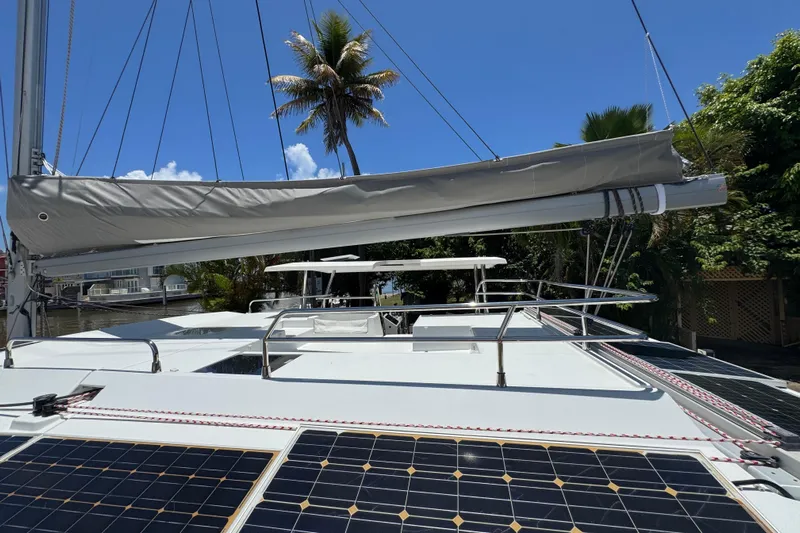 Ten:10 Yacht Photos Pics 2017 Fountaine Pajot SABA 50 catamaran with solar panels and palm tree backdrop.