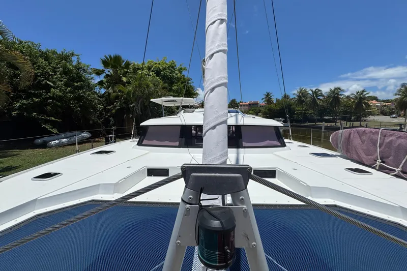 Ten:10 Yacht Photos Pics 2017 Fountaine Pajot SABA 50 catamaran docked, surrounded by lush greenery and clear blue skies.