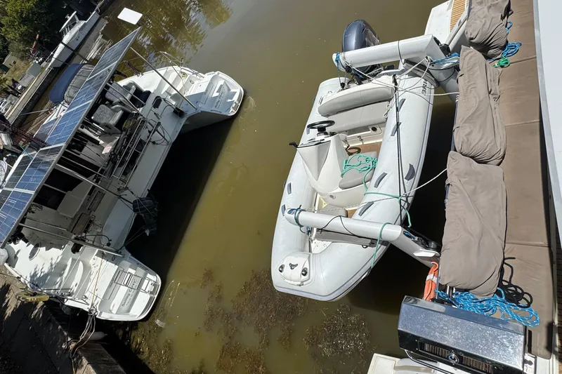 Ten:10 Yacht Photos Pics 2017 Fountaine Pajot SABA 50 catamaran with solar panels and inflatable dinghy in a marina.