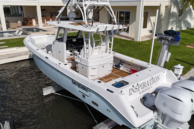  Yacht Photos Pics 2018 Everglades 335 Center Console boat docked near a modern waterfront home.