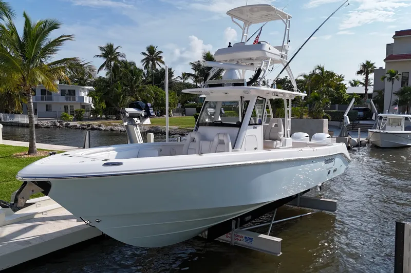  Yacht Photos Pics 2018 Everglades 335 Center Console boat docked by palm trees and waterfront homes.