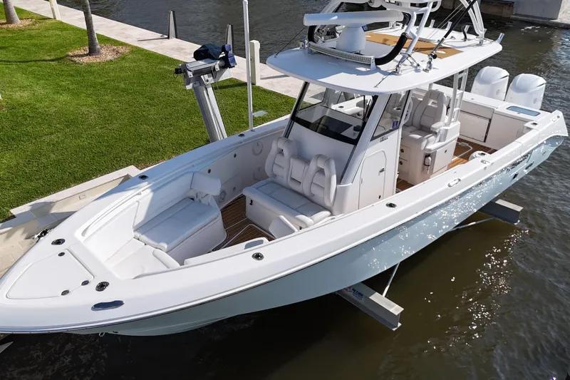  Yacht Photos Pics 2018 Everglades 335 Center Console boat docked by the water, showcasing sleek design and spacious seating.