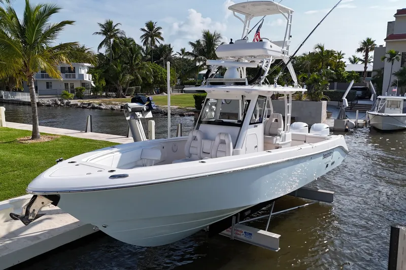  Yacht Photos Pics 2018 Everglades 335 Center Console boat docked by palm trees and waterfront homes.