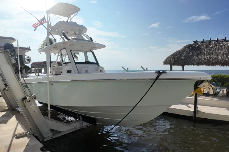  Yacht Photos Pics 2018 Everglades 335 Center Console boat docked by the ocean under a clear sky.