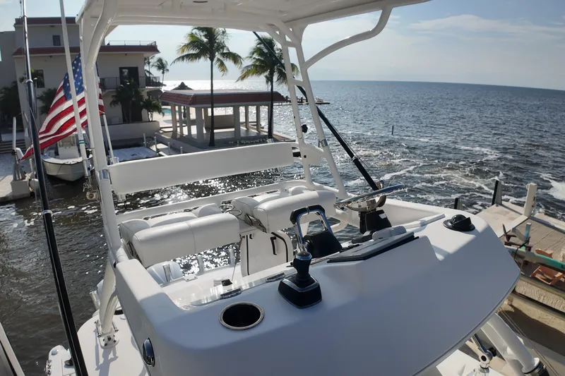  Yacht Photos Pics 2018 Everglades 335 Center Console boat docked by the ocean with palm trees.