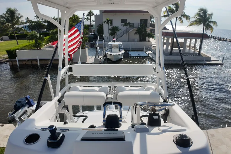  Yacht Photos Pics 2018 Everglades 335 Center Console boat docked near waterfront home, American flag visible.