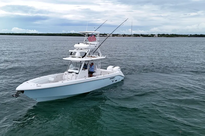  Yacht Photos Pics 2018 Everglades 335 Center Console boat on open water with fishing rods and American flag.