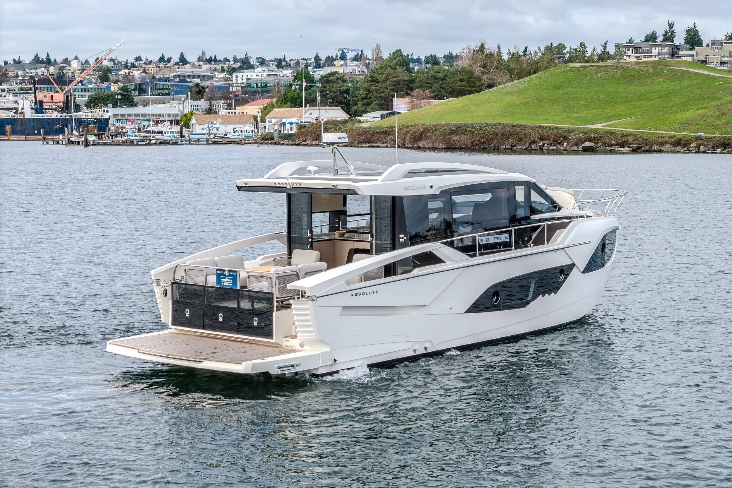 2026 Absolute 48 Coupe yacht cruising on a scenic waterfront.