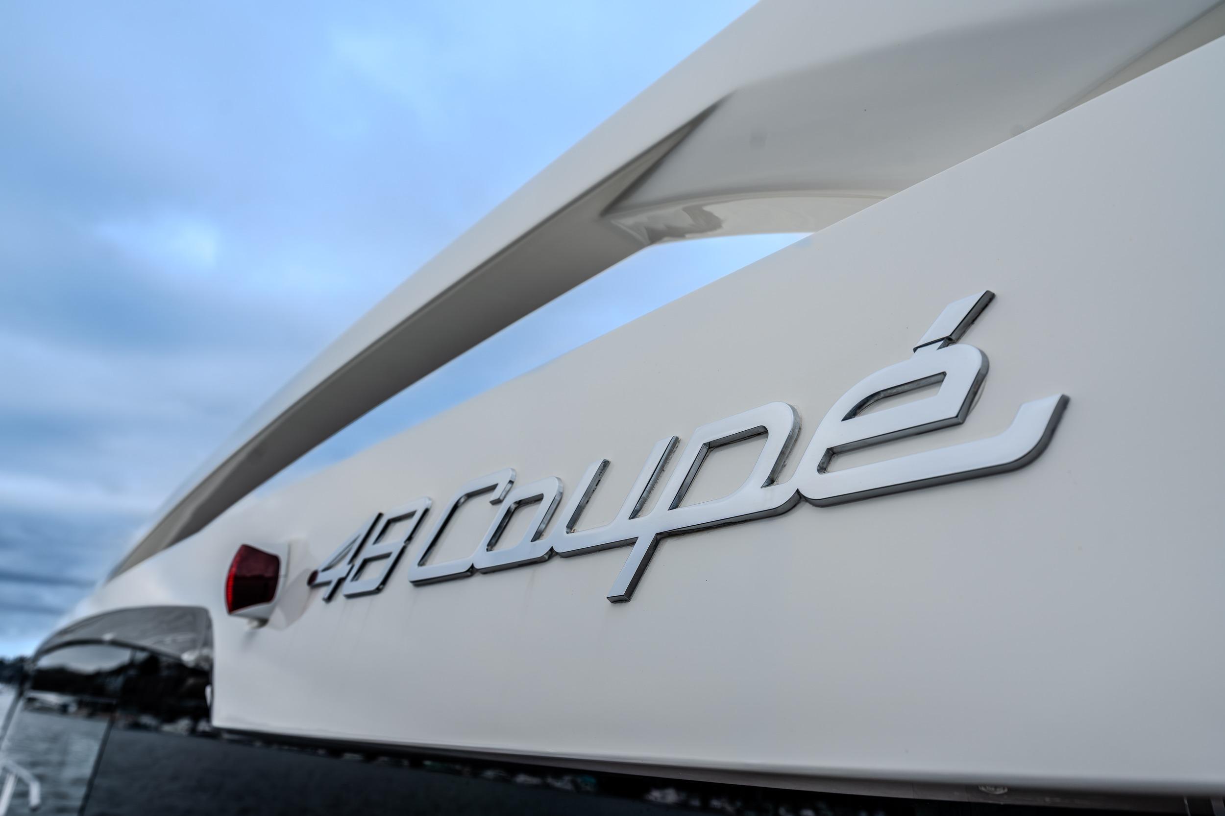2026 Absolute 48 Coupe yacht logo against a cloudy sky backdrop.