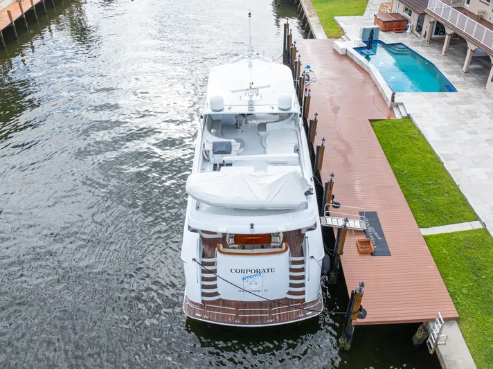 Corporate Approved 2 Yacht Photos Pics 2005 Hatteras 80 Motor Yacht docked beside a luxurious waterfront property with a pool.
