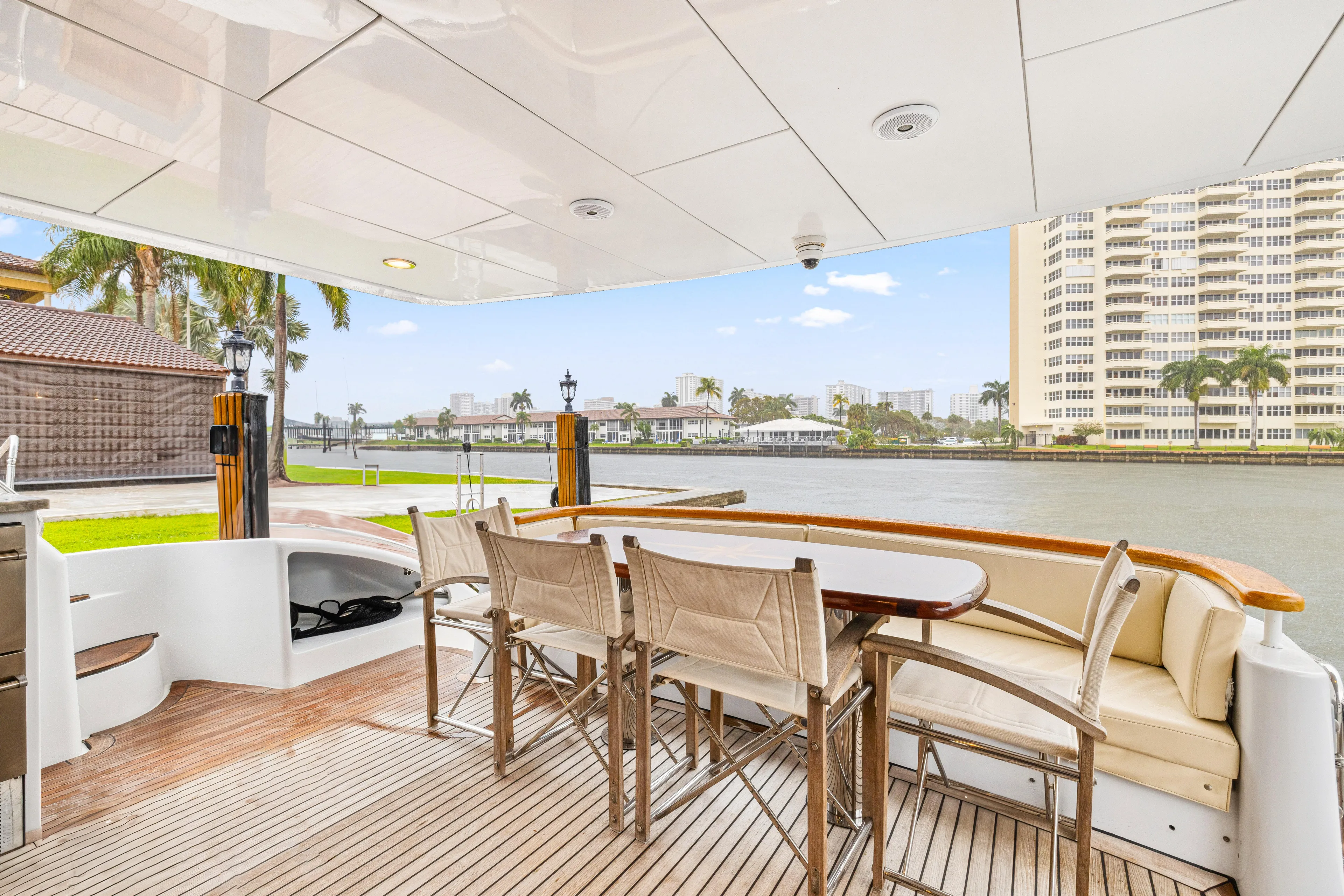 Corporate Approved 2 Yacht Photos Pics Outdoor dining area on 2005 Hatteras 80 Motor Yacht, overlooking waterfront and cityscape.
