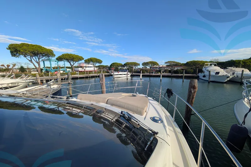  Yacht Photos Pics 2001 Azimut 42 Fly yacht docked in a serene marina under a clear blue sky.