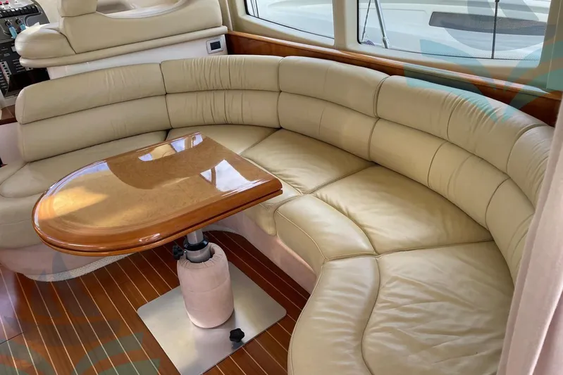  Yacht Photos Pics Luxurious interior of 2001 Azimut 42 Fly yacht with curved leather seating and wooden table.
