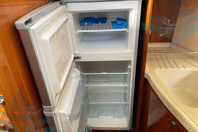  Yacht Photos Pics Open refrigerator in 2001 Azimut 42 Fly yacht kitchen, showcasing storage space.